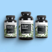 Drei Flaschen des Wonder Woman Bundle von NATURAL ELEMENTS vor hellblauem Hintergrund. Die Flaschen tragen die Aufschriften Eisen mit Vitamin C, Bio Maca Rot mit Vitamin C und D-Mannose.