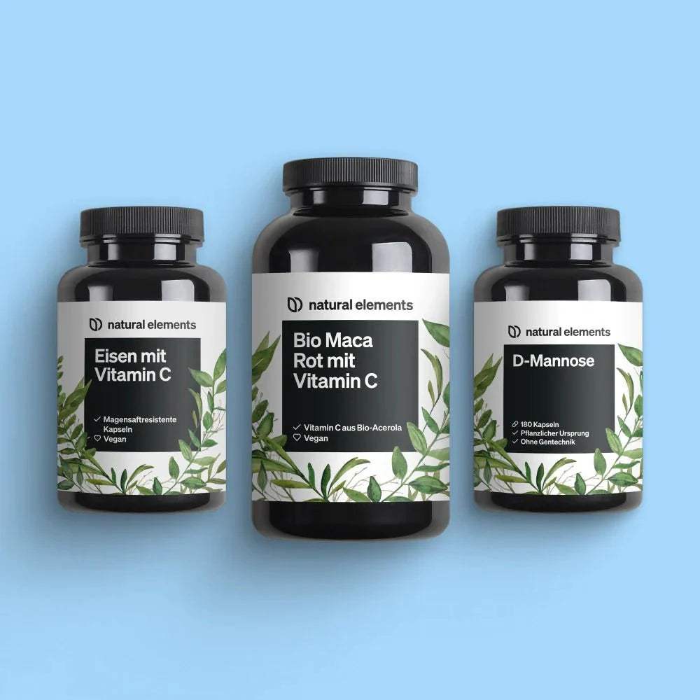 Drei Flaschen des Wonder Woman Bundle von NATURAL ELEMENTS vor hellblauem Hintergrund. Die Flaschen tragen die Aufschriften Eisen mit Vitamin C, Bio Maca Rot mit Vitamin C und D-Mannose.
